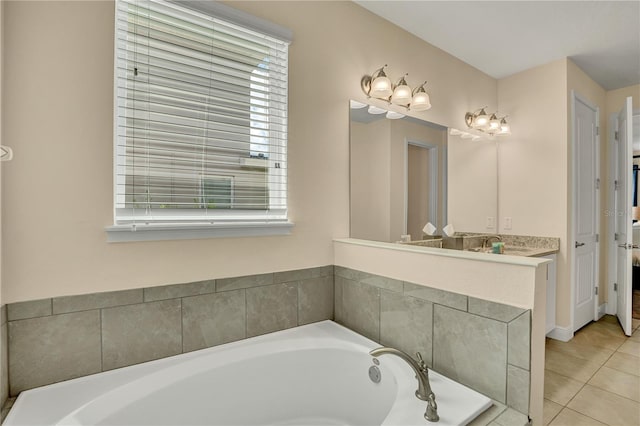 bathroom with tiled tub, vanity, and tile flooring