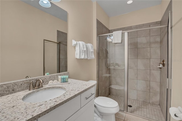 bathroom featuring an enclosed shower, vanity, tile floors, and toilet