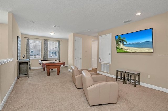 recreation room with light colored carpet, pool table, and a textured ceiling