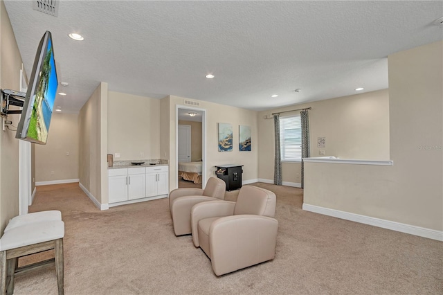 living room featuring light carpet and a textured ceiling