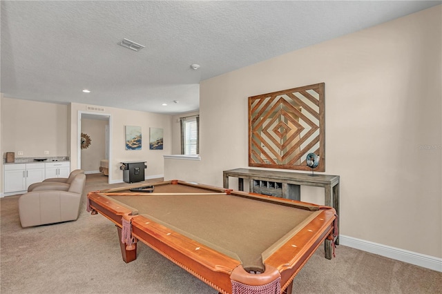 recreation room with billiards, a textured ceiling, and light colored carpet