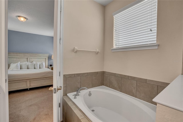 bathroom with tiled bath and a textured ceiling