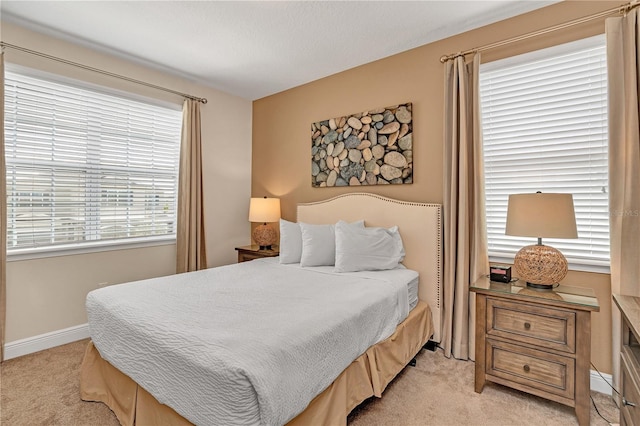 bedroom with light carpet and multiple windows