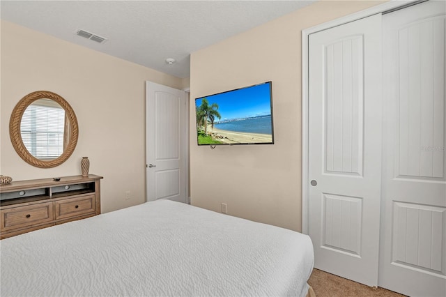 bedroom featuring light colored carpet and a closet