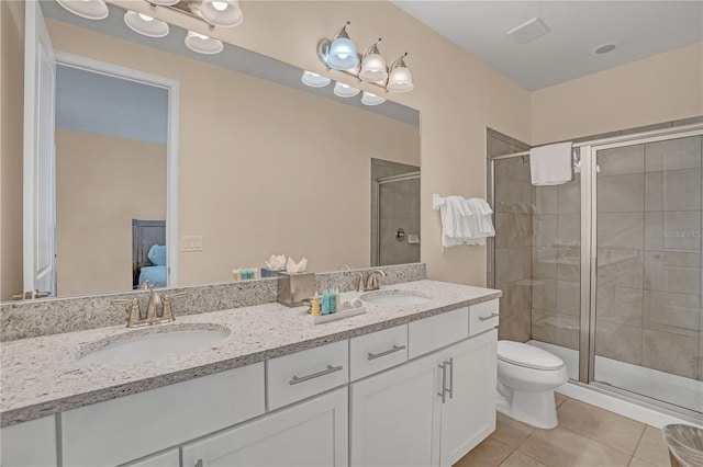 bathroom featuring tile flooring, a shower with door, dual sinks, toilet, and oversized vanity