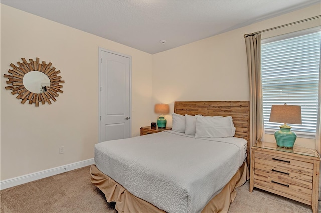 bedroom with light carpet and multiple windows