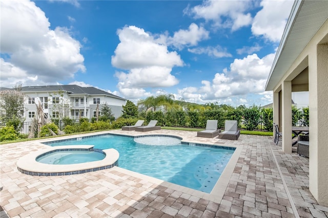 view of pool with a patio and an in ground hot tub