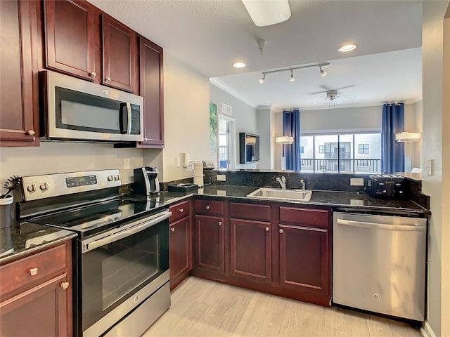 kitchen featuring rail lighting, sink, light wood-type flooring, and appliances with stainless steel finishes