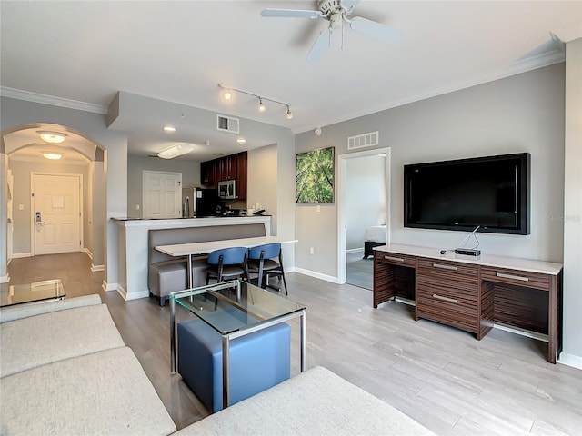 living room with track lighting, ornamental molding, ceiling fan, and light wood-type flooring