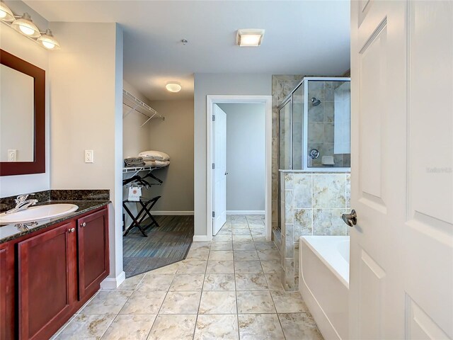 bathroom with tile floors, independent shower and bath, and vanity