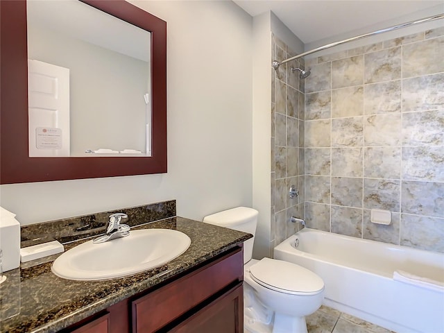 full bathroom with tile floors, oversized vanity, toilet, and tiled shower / bath combo