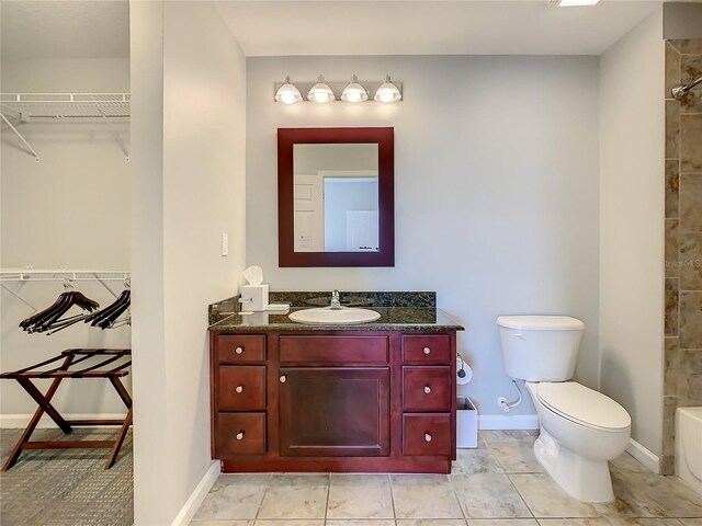 full bathroom featuring tile floors, tiled shower / bath combo, vanity, and toilet