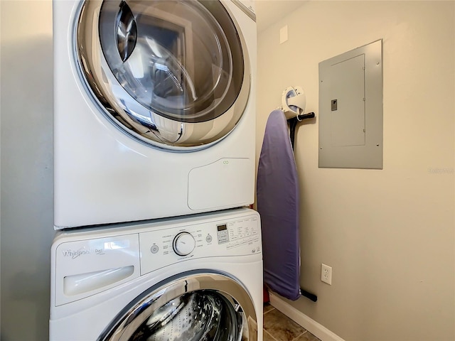 washroom with tile floors and stacked washer / drying machine