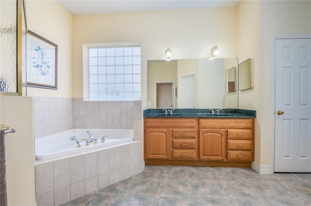 bathroom featuring tile floors, tiled bath, and dual bowl vanity