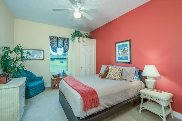 carpeted bedroom featuring a textured ceiling and ceiling fan