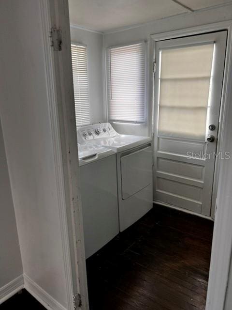 laundry area with washer and dryer and dark wood-type flooring