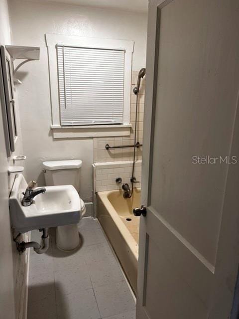 bathroom featuring toilet, tile floors, and sink