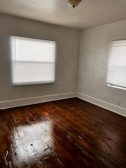 unfurnished room with dark wood-type flooring