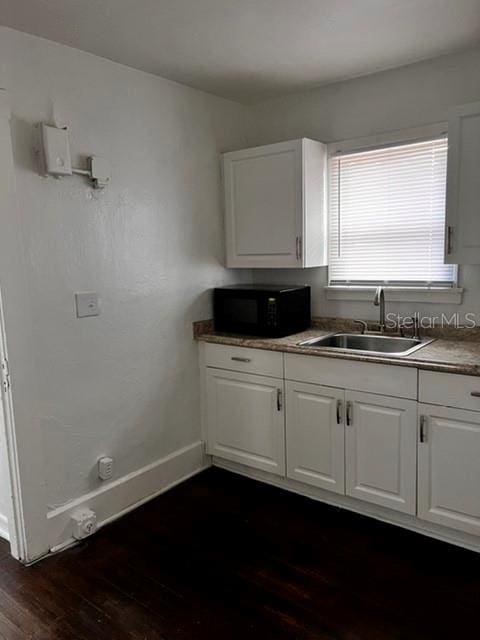 kitchen with white cabinetry, dark hardwood / wood-style flooring, and sink