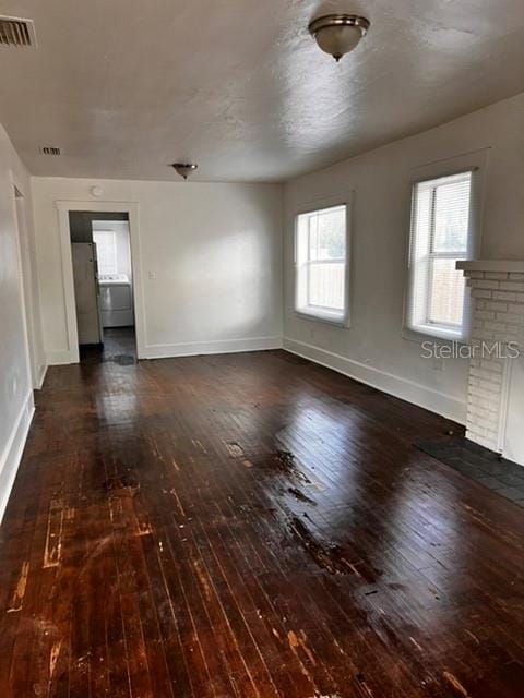 empty room with dark wood-type flooring and a fireplace