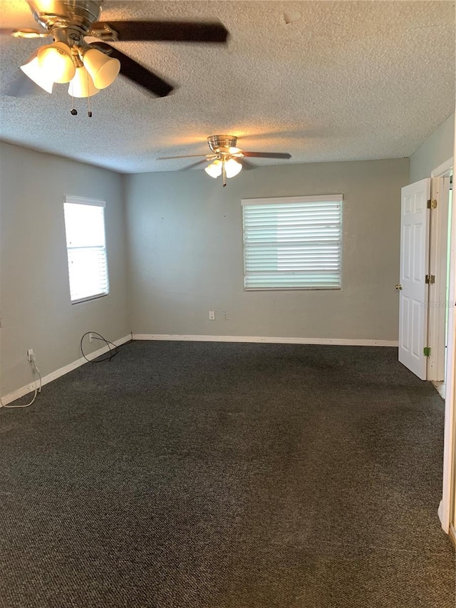 empty room with a textured ceiling, ceiling fan, and dark carpet