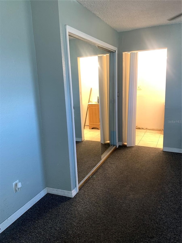 unfurnished bedroom featuring a closet, a textured ceiling, and carpet floors