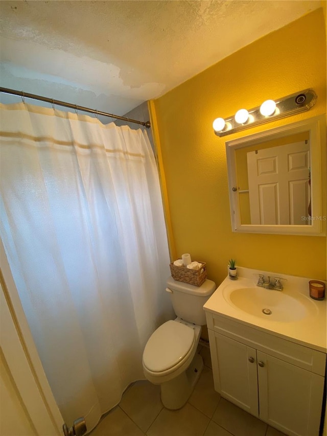 bathroom with tile patterned flooring, toilet, and vanity