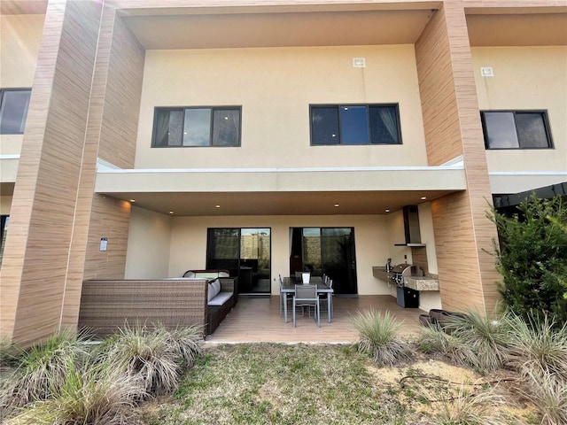 back of property featuring stucco siding, an outdoor hangout area, and a patio