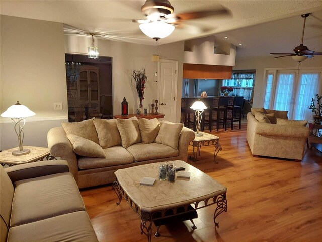 living room featuring lofted ceiling, hardwood / wood-style floors, and ceiling fan