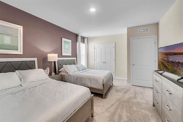 bedroom with light colored carpet and a closet