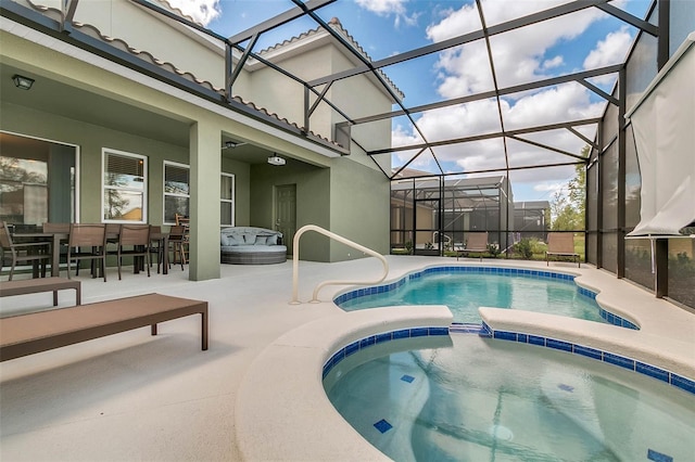 view of pool featuring a patio, glass enclosure, and an in ground hot tub