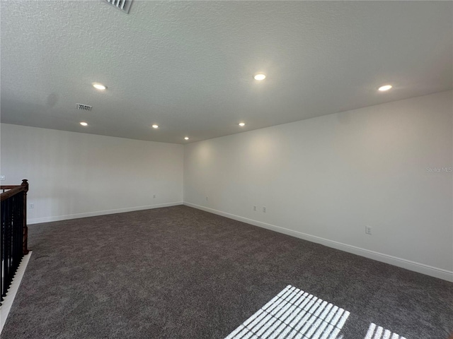 carpeted spare room featuring a textured ceiling