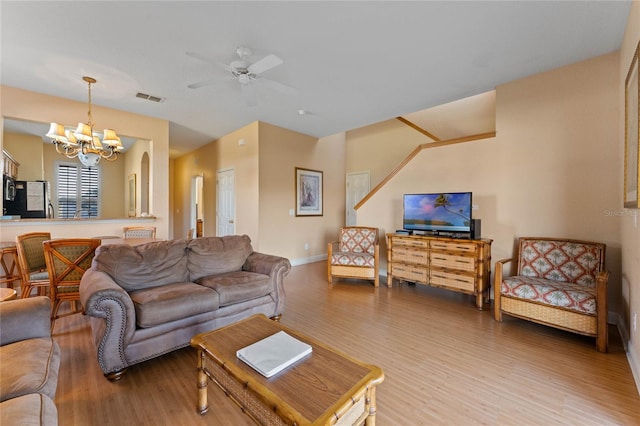 living room featuring hardwood / wood-style floors and ceiling fan with notable chandelier