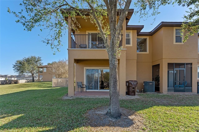 back of house with cooling unit, a yard, and a balcony