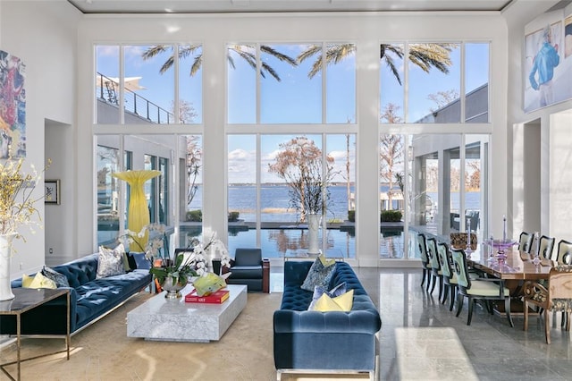 sunroom / solarium with plenty of natural light, french doors, and a water view