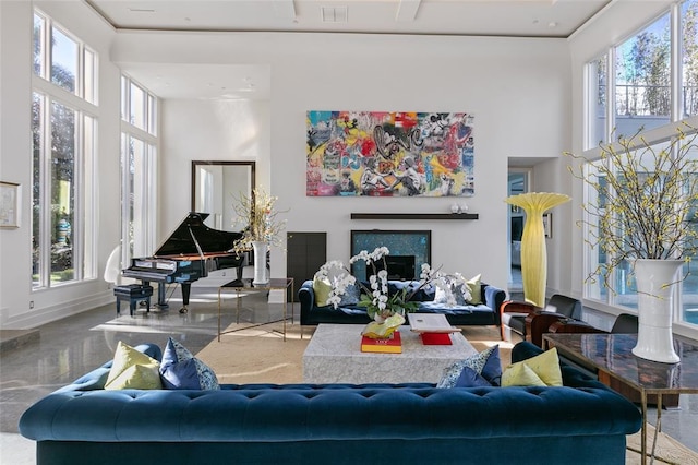 living room with plenty of natural light, concrete floors, and a towering ceiling