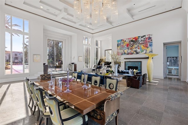 dining room featuring a high ceiling, a chandelier, and a healthy amount of sunlight