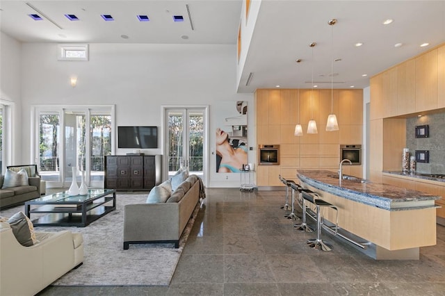 interior space featuring french doors, dark tile floors, sink, and a towering ceiling