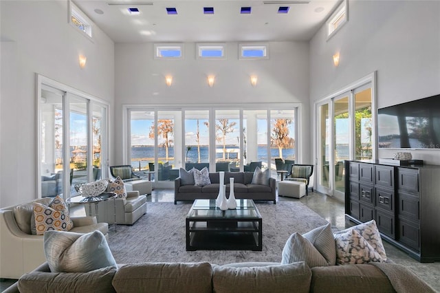 living room with a water view, a high ceiling, and a wealth of natural light