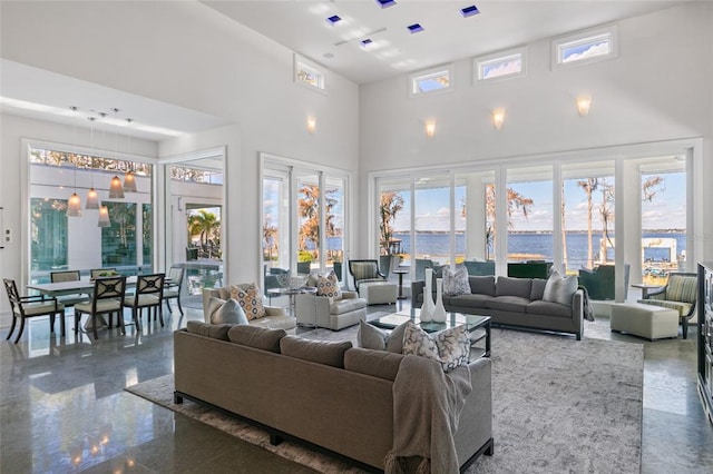 living room with a water view and a towering ceiling