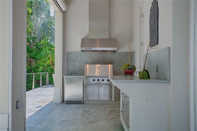 interior space featuring light tile floors, wall chimney exhaust hood, tasteful backsplash, and fridge