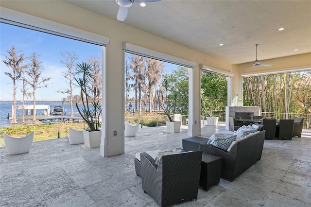 view of patio with a water view, outdoor lounge area, and ceiling fan