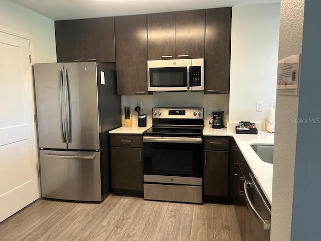 kitchen featuring sink, light hardwood / wood-style flooring, dark brown cabinetry, and stainless steel appliances