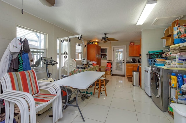 tiled dining room with ceiling fan, washer and dryer, and a textured ceiling