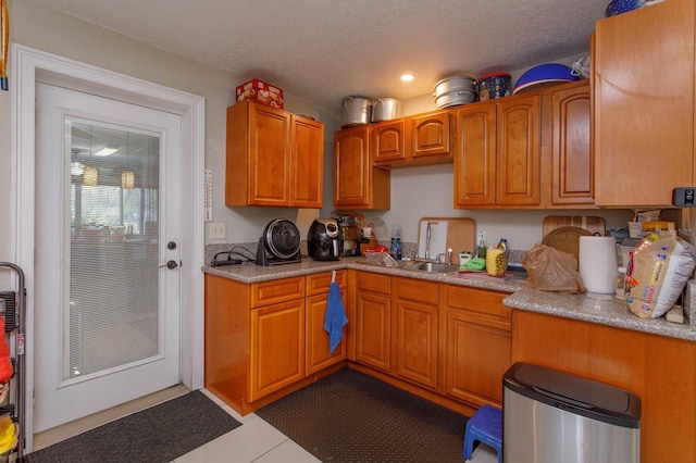 kitchen with a sink, light countertops, and a textured ceiling