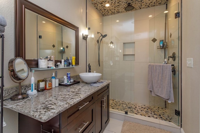 bathroom featuring vanity, a shower with shower door, and tile patterned floors