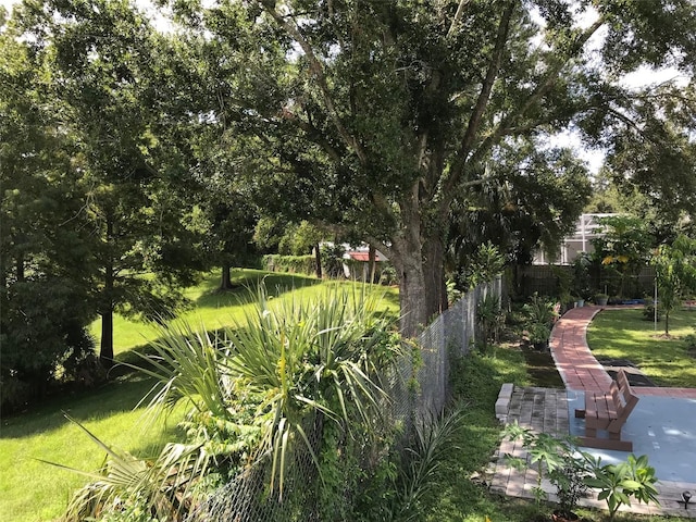 surrounding community with fence and a yard