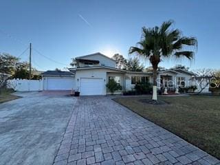 single story home with a garage, a front lawn, and decorative driveway