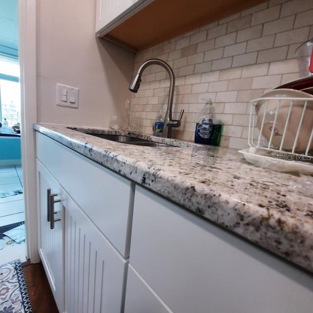 interior details with backsplash, dark hardwood / wood-style floors, and vanity