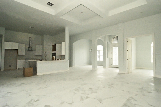 unfurnished living room featuring coffered ceiling and beam ceiling